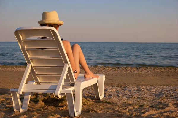 Mujer chateando smartphone en chaise longue en la playa . —  Fotos de Stock