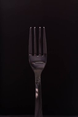 Siyah arkaplanda paslanmaz çatal.