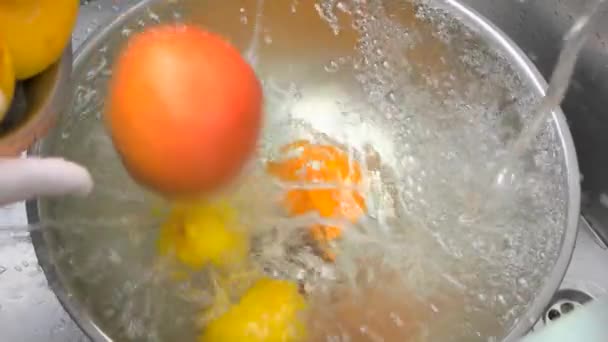 Zitrusfrüchte aus nächster Nähe, die in ein Wasser fallen. — Stockvideo