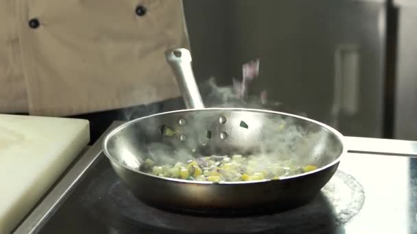Koch gießt gehackte rote Zwiebeln in eine heiße eiserne Pfanne. — Stockvideo