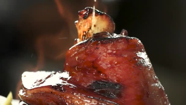 Appetizing lamb shank oiling and burining. — Stock Video