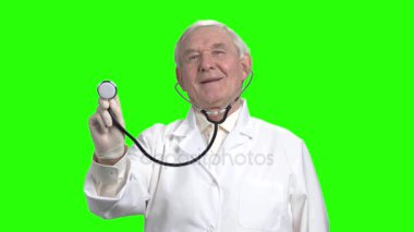 Yaşlı doktor stetoskop kullanarak ve gülümseyen.