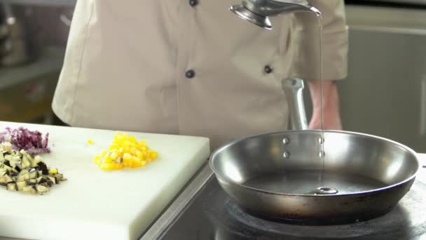 Chef-kok stromende olie in de pan. — Stockvideo