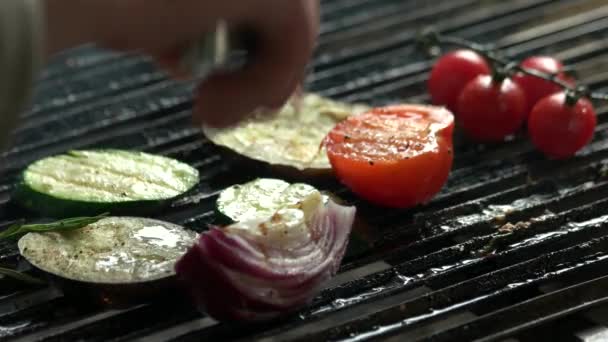 Mano con pinzas para asar comida . — Vídeo de stock