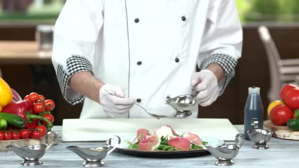 Chef derramando molho na salada . — Vídeo de Stock