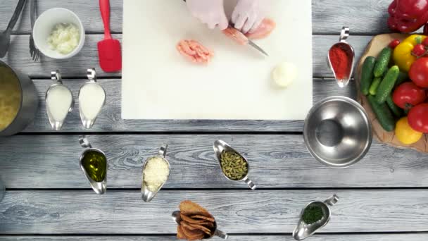 Mains coupant poitrine de poulet crue .