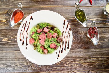 Sığır eti, turşu ve hardal ile yeşil salata.