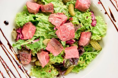 Sığır eti adet marul salatası ve salatalık turşusu ile.