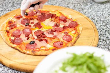 Salam pizzaya yağmurlama zeytin.