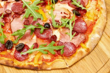 Zeytin ve roka ile pepperoni pizza yakın.