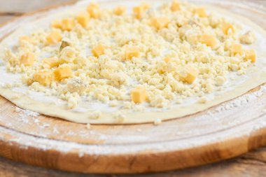Kıyılmış peynir pizza kabuk üzerinde kapatın.