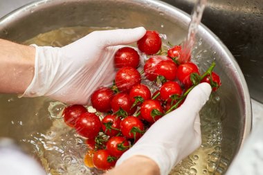 Kiraz domates Buhar holding Şef eller bağlı.