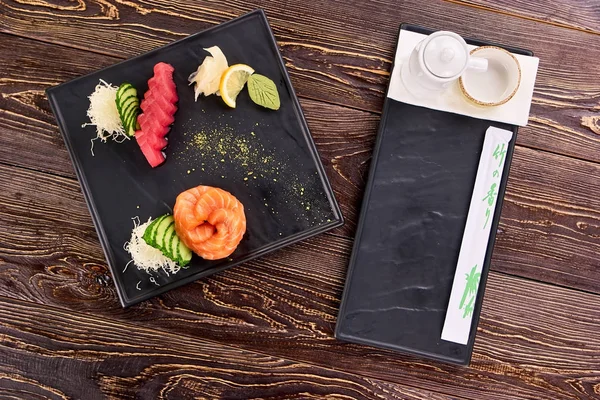 Sushi jugoso fresco apetitoso en plato negro cuadrado . — Foto de Stock