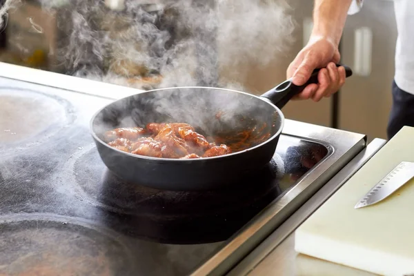 Kycklingvingar i tomatsås är matlagning på pan. — Stockfoto