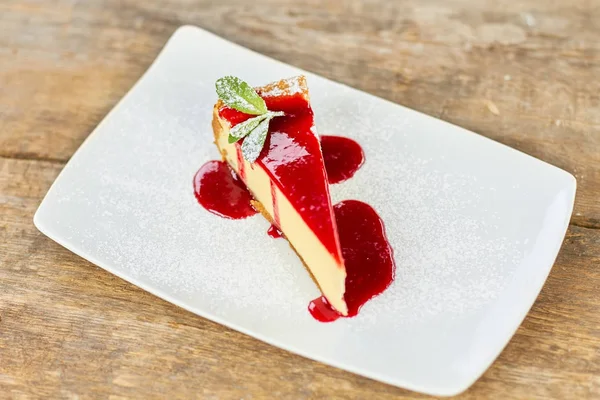 Dessert - Kaastaart met bessensaus en groene munt. — Stockfoto