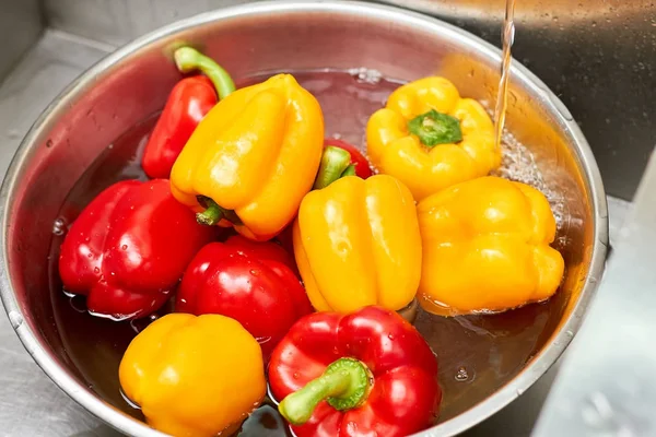 Poivrons rouges et jaunes dans un bassin d'eau, gros plan . — Photo