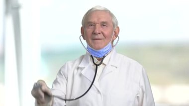 Eski kıdemli neşeli doktor stetoskop ile.