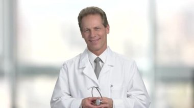Erkek tıp doktor stetoskop üzerinde başını koyar ve dinle.