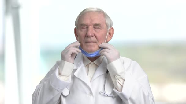 Senior kirurg i vit kostym satte på medicinska mask. — Stockvideo