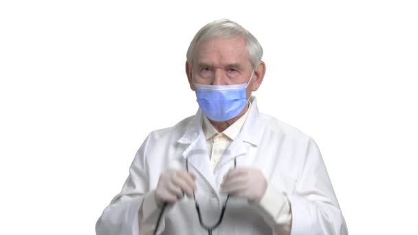 Oude dokter in masker luisteren naar uw hartslag met behulp van de stethoscoop. — Stockvideo