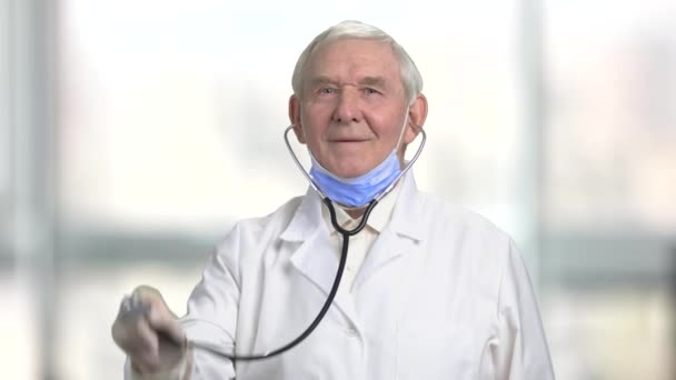 Vorderansicht alter Mann Arzt mit Thetoskop lächelnd. — Stockvideo