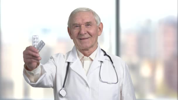 Stary lekarz przytrzymaj pasek medycyny. — Wideo stockowe