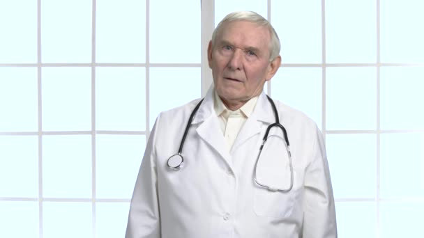 Bezorgd ernstige oude arts met de stethoscoop portret. — Stockvideo