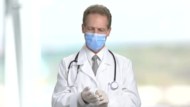 Doctor put on gloves and fold hands. — Stock Video