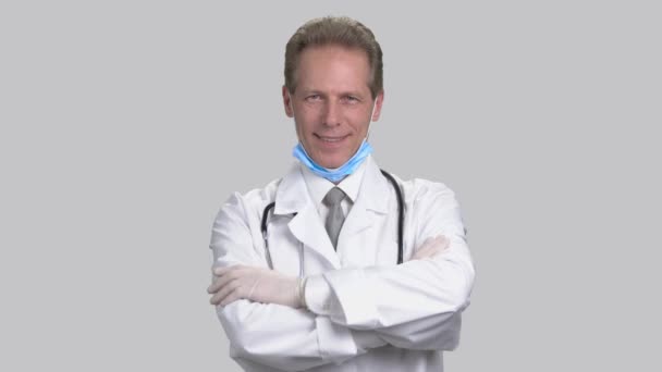 Mature doctor wearing medical gloves and folding arms. — Stock Video