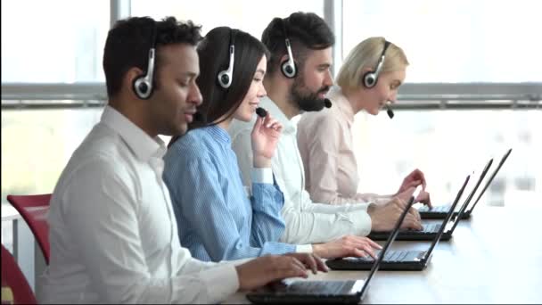 Operadores con auriculares en oficina luminosa . — Vídeos de Stock