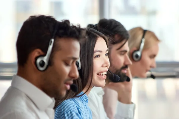 Cuatro operadores de telefonía de apoyo en el lugar de trabajo . — Foto de Stock