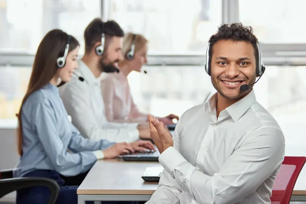 Call center operator pointing at his colleagues. — Stock Photo, Image