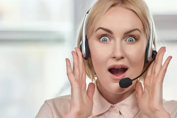 Portrait of extremely surprised woman with headset.