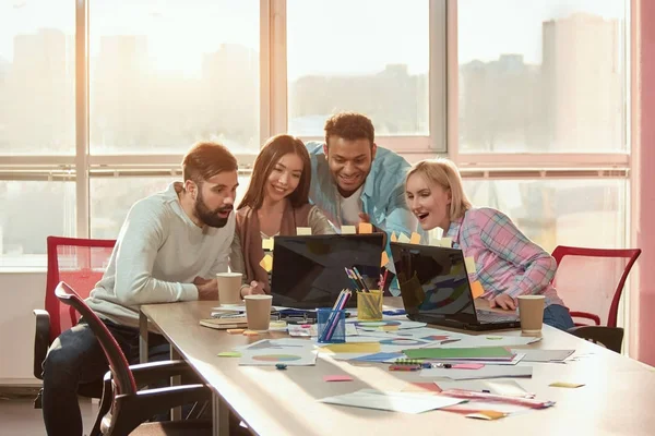 La gente en la oficina viendo videos divertidos en el ordenador portátil . — Foto de Stock