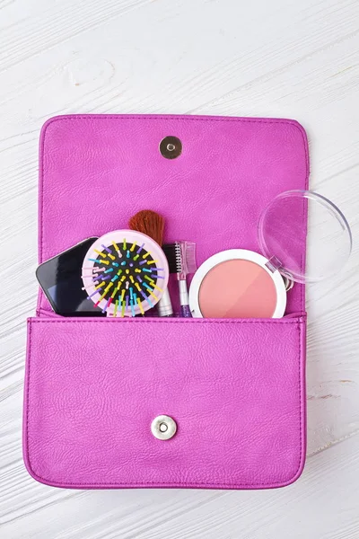 Women bag stuff on wooden background.