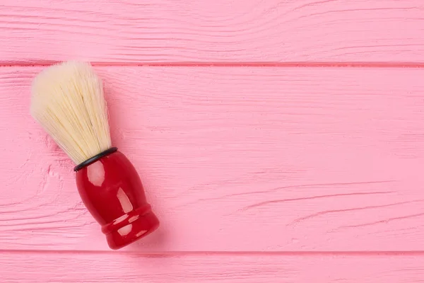 Shaving brush on a wooden background.