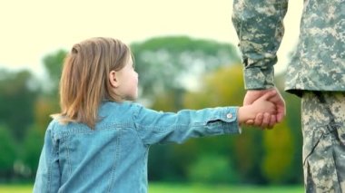 Askeri babasının elini tutarak kızı.