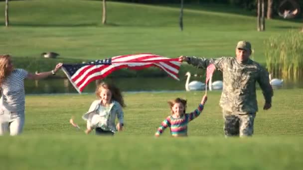 Patriotische Familie läuft mit riesigem US-Hintergrund im Freien. — Stockvideo