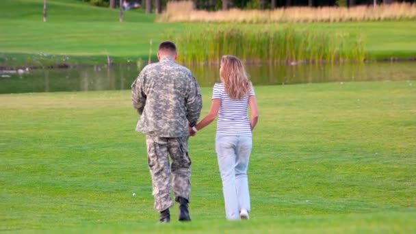 Voltar vista militar homem na data em um gramado parque . — Vídeo de Stock