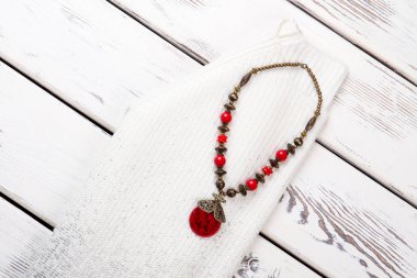 Kadın beyaz kazak ve renkli kolye.