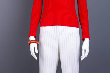 Kırmızı kazak ve bilezik takan manken.