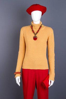 Sarı kazak ve kırmızı kadın pantolonlar.