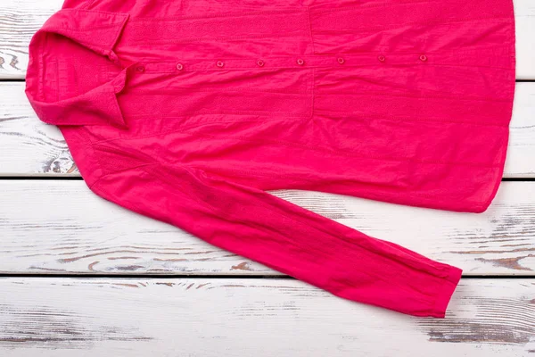 Camisa roja femenina sobre fondo de madera . — Foto de Stock