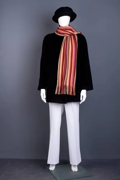 Female mannequin with black coat and scarf.