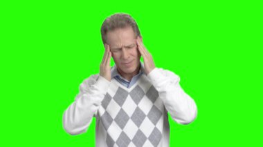 Baş ağrısı, yeşil arka plana sahip olgun adam.