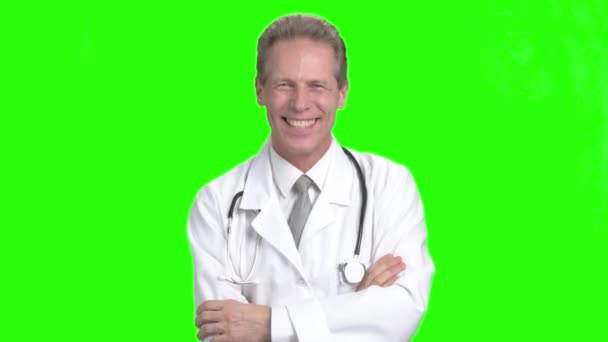 笑いの男性医師は、緑の背景. — ストック動画