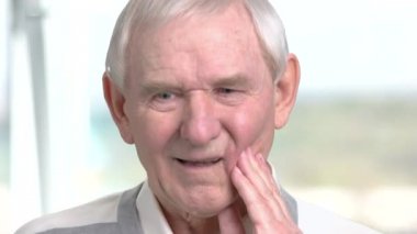 Yaşlı adam toohache, sahip arka plan bulanık.