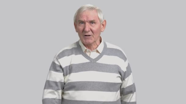 Frustrierter älterer Mann auf grauem Hintergrund. — Stockvideo