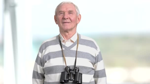 Homem idoso com binóculos em volta do pescoço . — Vídeo de Stock