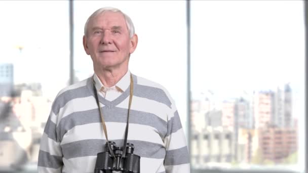 Hombre mayor posando con prismáticos . — Vídeos de Stock